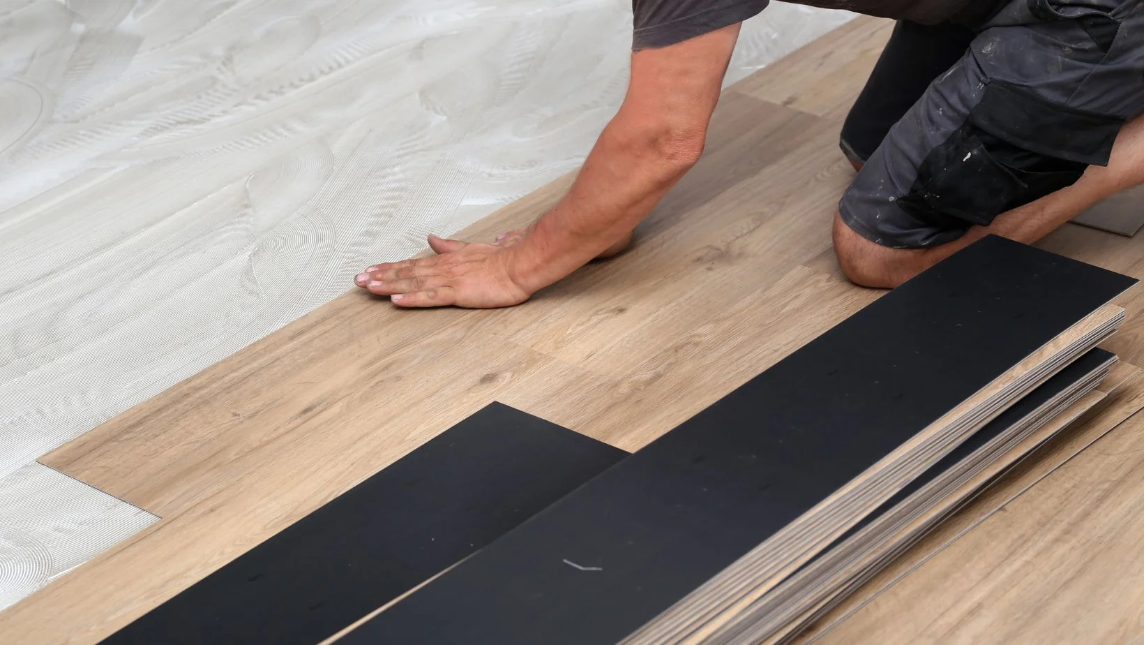 man installing vinyl flooring